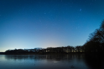Fototapeta premium Sterne in der Nacht über dem See im Winter