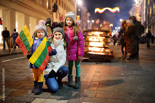 Family with kids attending the celebration of Restoration of the State Day in Vilnius, Lithuania. Bonfires are lit on Gediminas avenue on the night on February 16.