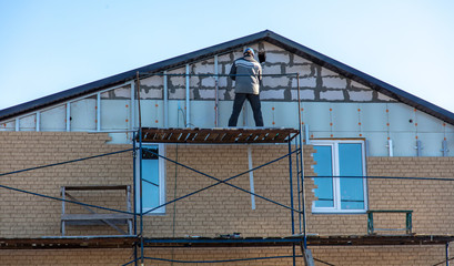 Installation of siding on the walls of the house