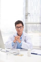 Portrait of senior doctor sitting in medical office