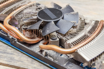 Dust on CPU cooler video card computer close up on wooden table