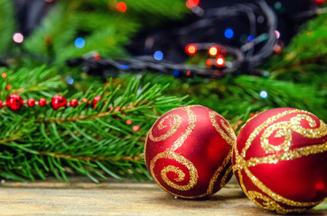 Two red Christmas balls on the background of Christmas tree branches close-up. Beautiful Christmas and New year background
