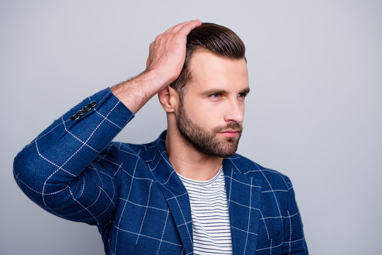 Close up photo of serious confident man applying balm on his hair to look better with bristle on unshaven face isolated grey color background