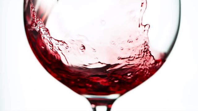 Super slow motion of pouring red wine in detail, isolated on white background. Filmed on high speed cinema camera, 1000 fps