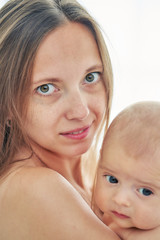 young mother holding her newborn child. vertical closeup