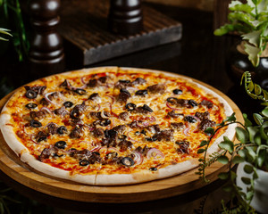 meat pizza with red onion rings, olive and cheese