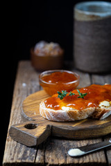 Closeup of pieces of white bread with apricot jam on dark background