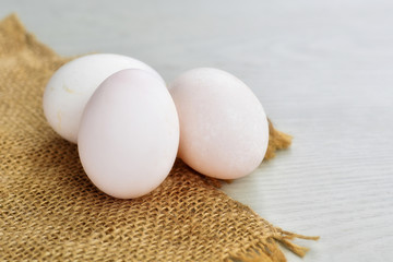 White duck eggs on sackcloth with copy space.