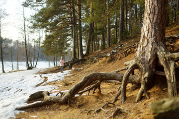 Cute young girl having fun during forest hike on beautiful winter day. Active family leisure with kids.