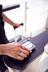 Close Up Of Passenger In Airport Departure Lounge Scanning Digital Boarding Pass On Smart Phone