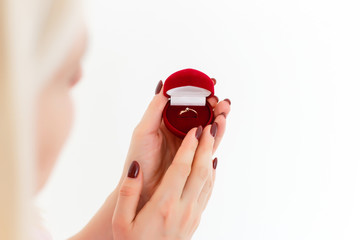 Women look at the engagement ring in a red velvet case.