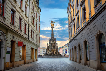 Street in centre city with view to square and monument of Holy Trinity Column. Olomouc, Czech Republic - obrazy, fototapety, plakaty