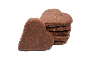Delicious homemade chocolate and sugar cookies in the shape of hearts, piled up on top of each other and one stands nearby, isolated on a white background. Holiday baking for the whole family