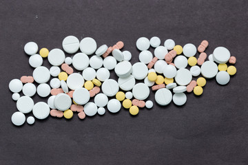 Colorful medical pills on a black background, for your text