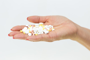 in the girl’s hand a lot of pills on a white background
