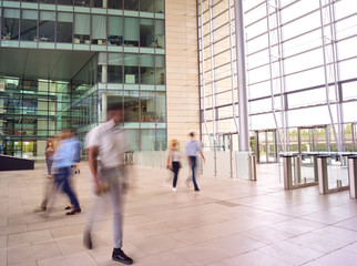 Motion Blur Shot Of Businesspeople In Lobby Of Busy Modern Office