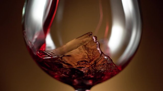 Super slow motion of pouring red wine into glass in detail. Filmed on high speed cinema camera, 1000 fps