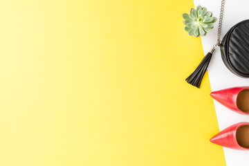 Red high heels and black purse on abstract background with copyspace. Fashion background