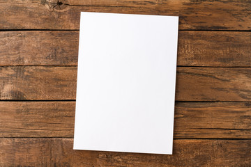 Empty white paper sheet on rustic wooden table. Top view - Powered by Adobe