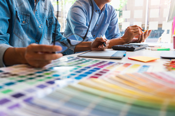Fototapeta premium designer graphic creative creativity working together coloring using graphics tablet and a stylus at desk with colleague.