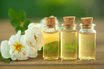Essence of rose on table in beautiful glass bottle