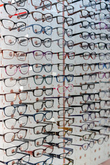 A large assortment of different glasses on a shelf in an optics store