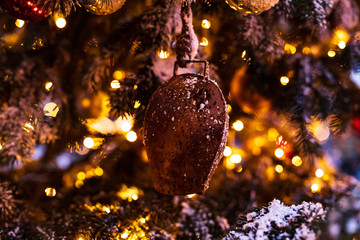 Christmas tree decorated with vintage bells and balls on a blurred abstract sparkling background