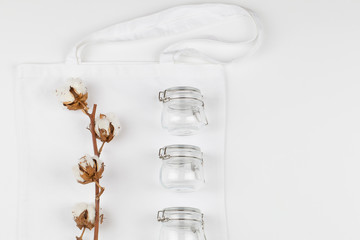 Cotton flower with glass on eco white natural bag on white background. copy space