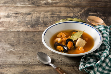 French bouillabaisse soup on wooden table. Copy space	