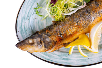 Sibas fried on coal with greens and lemon slices