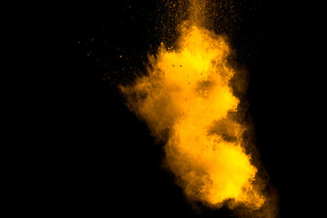Fototapeta na wymiar Abstract orange powder explosion on black background. Freeze motion of orange powder splash.