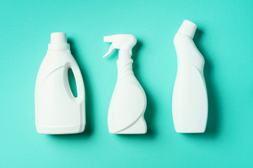 Composition with plastic bottles of cleaning products over blue background. Top view. Flat lay....