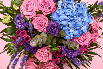 Beautiful bouquet of pink, purple and blue flowers on pastel pink background, copy space. Greeting card for Womens Day, Mothers Day, Valentines Day, wedding, birthday. Top view, flat lay