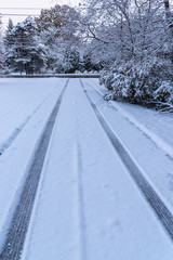 Tire tracks in snow on driveway in winter