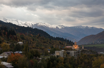 Fototapeta na wymiar Early morning panoramic view of Mestia village in Svaneti and the snow-capped peaks of the mountains in the distance in the mountainous part of Georgia