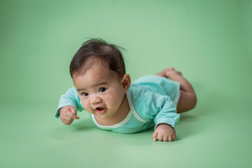 baby laying on her belly. tummy time cute baby in studio portrait