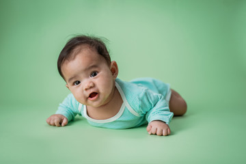 cute baby laying on her belly looking at camera