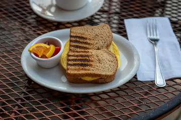 Egg sandwich and fruit with cofffee in restaurant setting close-up dinner angle view