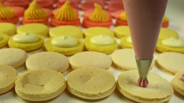 Chef with injector squeezing macaron cream