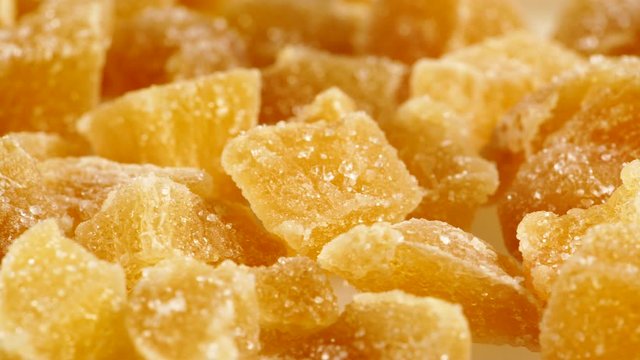 Close up heap of crystallized candied ginger pieces rotating.  Yummy snack, better alternative to candy