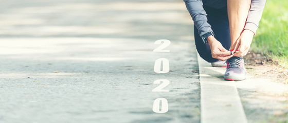The start into the new year 2020. Start up of runner woman running on nature race track go to Goal...
