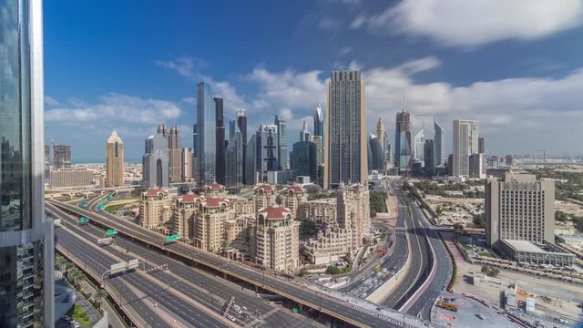 Skyline all day view of the buildings of Sheikh Zayed Road and DIFC timelapse with fast moving shadows in Dubai, UAE. Skyscrapers in financial centre aerial view from above in downtown