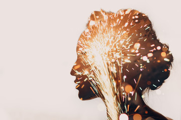 Face silhouette of a young beautiful woman with sparks inside