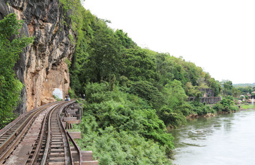 Fototapeta na wymiar Scenery of railway beside the mountain and river with tropical forest.