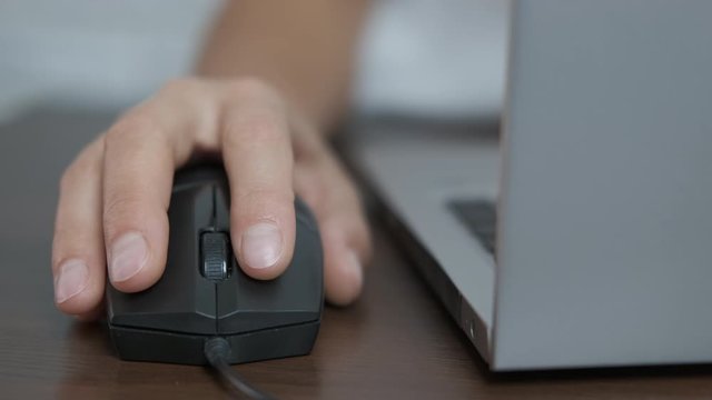 Hand on a computer mouse.