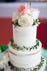 White wedding cake with rose and leaves.