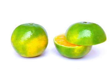 Green oranges and sliced isolated on a white