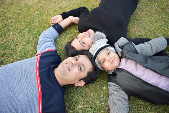 happy young family lying on grass