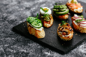 Bruschetta with mushrooms, cucumbers, avocado, radish, salmon and egg