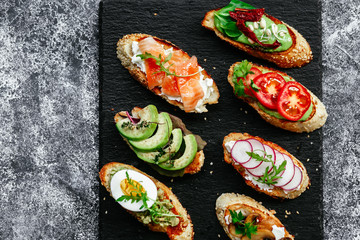 Bruschetta with mushrooms, cucumbers, avocado, radish, salmon and egg